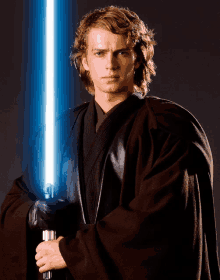 a young man in a black robe holds a light saber