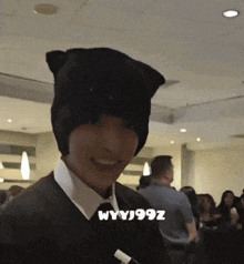 a man wearing a cat ear hat is smiling in a crowd