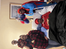 a woman in a spiderman costume stands next to a man in a hospital bed