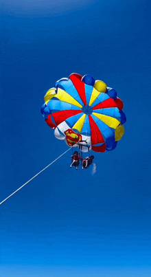 two people are parasailing with a parachute that has superman on it