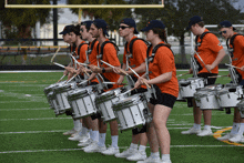 a marching band is playing drums on a field