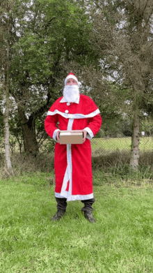 a man dressed as santa claus is holding a box in his hands