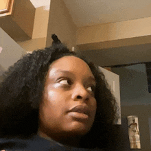 a woman with curly hair is looking at the camera