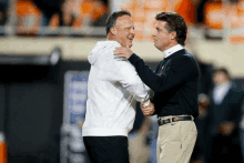 two men are shaking hands on a football field