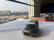 a toy land rover defender sits on a table