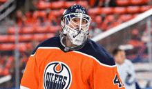 a hockey player wearing a helmet and a jersey that says oilers on it