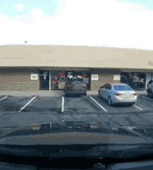 a white car is parked in a parking lot in front of a building with a sign that says yoga