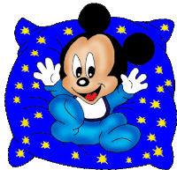 a baby mickey mouse sitting on a blue pillow with stars on it