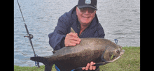 a man is holding a large fish in his hands