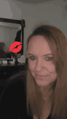 a woman is taking a selfie with a red kiss on her face