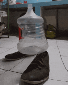 a bottle of water sitting on top of a pair of shoes