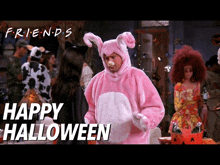 a man in a pink bunny costume is standing in front of a sign that says happy halloween