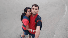 a man and woman pose for a picture on the beach