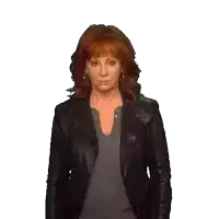 a woman with red hair is wearing a black jacket