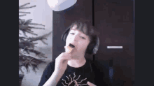 a boy wearing headphones is eating a piece of food .