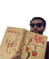 a man wearing sunglasses is holding a cookbook called the gay cookbook