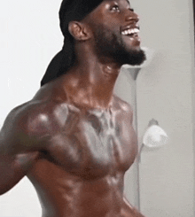 a shirtless man with a beard is smiling and laughing .