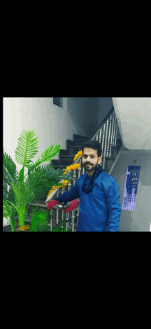 a man in a blue shirt stands in front of a staircase