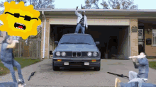 a man is standing on top of a car in front of a house with a sign that says ' no parking '