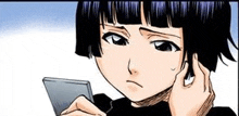 a girl with short black hair is holding a cell phone in her hand and looking at it .