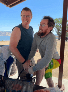 a man wearing shorts with the letter p on them is squatting next to another man