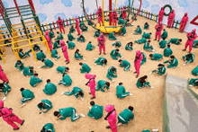 a group of people are playing a game of squid game in a playground .