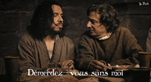 two men sitting at a table with the words demerdez vous sans moi on the bottom right