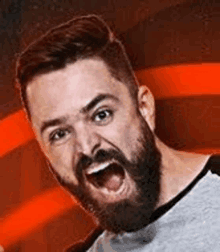 a man with a beard is screaming with his mouth open in front of an american flag .