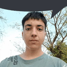 a young man wearing a blue shirt has a speech bubble behind him