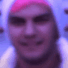 a blurry picture of a man wearing a pink hat and a white hoodie .