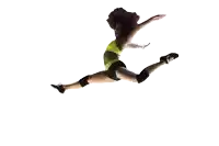 a woman in a yellow sports bra and black shorts jumps in the air