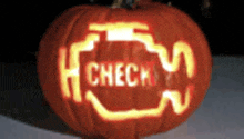 a carved pumpkin has the word check carved into it .