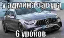 a mercedes benz is parked in a parking lot with a russian text .