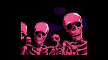 a group of pink skulls are standing next to each other in a dark room .