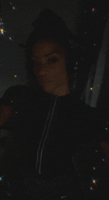 a woman is wearing headphones in the dark and taking a selfie .