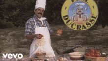 a man in a chef 's hat and apron is standing in front of a ducasse logo