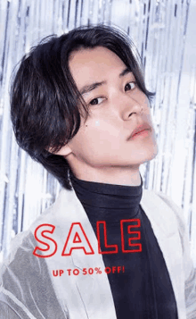 a young man is wearing a black turtleneck and a white jacket with the words sale up to 50 % off written on it .