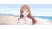 a girl with brown hair is standing on a beach with her hands on her chest