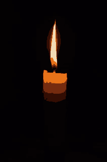 a lit candle in the dark with a flame coming out of it