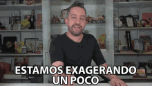 a man in a black shirt says estamos exagerando un poco in front of a bookshelf