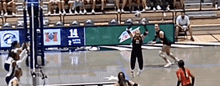 a volleyball game is being played on a court with a banner that says 14 on it .