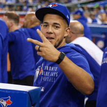 a man wearing a blue shirt that says toronto blue jays baseball on it