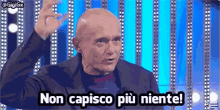 a bald man is standing in front of a blue background and says non capisco più niente .