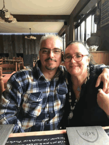 a man and woman are posing for a picture in a restaurant