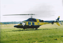 a yellow and black helicopter is parked on a runway