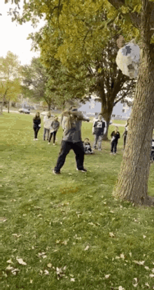 a group of people are playing in a park with a man wearing a jersey that says ' cowboys ' on it