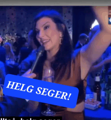 a woman holding a microphone with a blue sticker that says helg seger on it