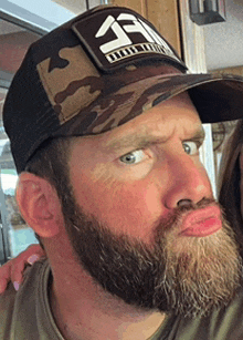 a man with a beard wearing a hat that says ' a ' on it