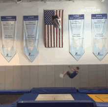 a gymnast is doing a trick in front of banners that say 2009 state champions 2008 state champions 2007 state champions and 2006 state champions