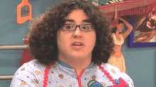 a young man with curly hair and glasses is wearing a diaper and an apron .